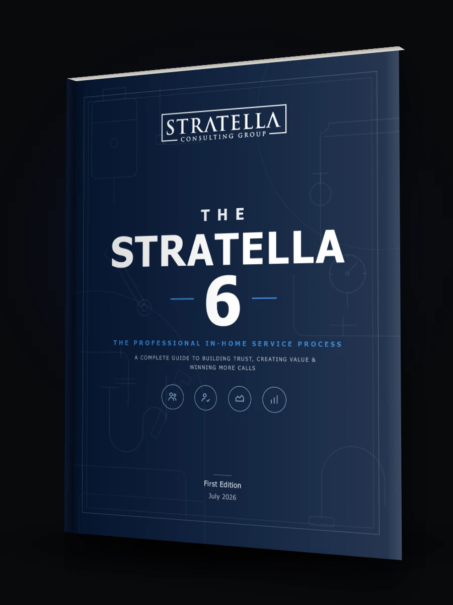 The Stratella 6, a navy softcover with a blueprint background, standing on a dark surface.